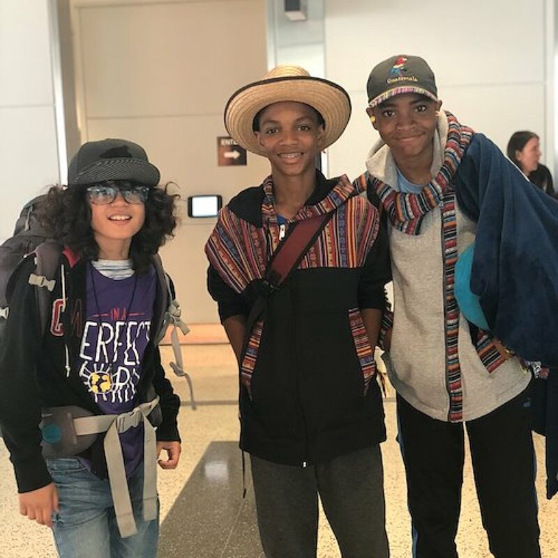 three young kids from the U.S. stand in the airport in Guatemala