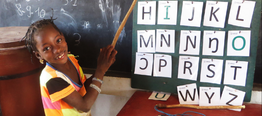 a School girl in Haiti working on a chalkboard