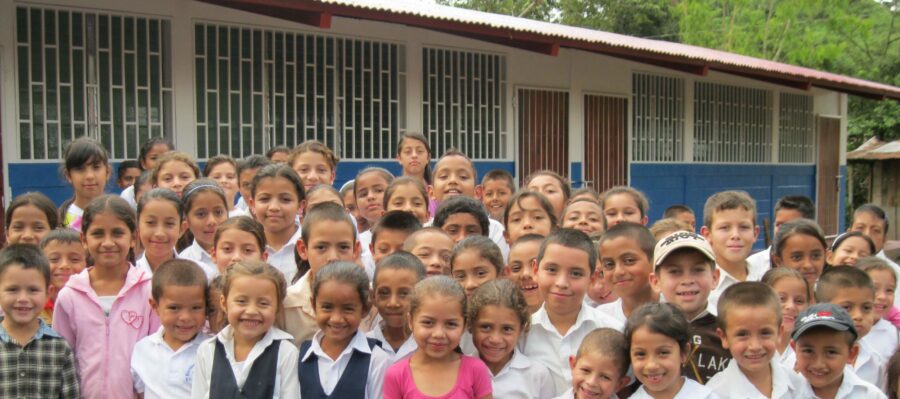 School children in Nicaragua stand in front of their school