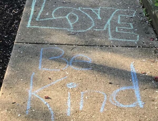 chalk on a sidewalk that says Love and Be Kind